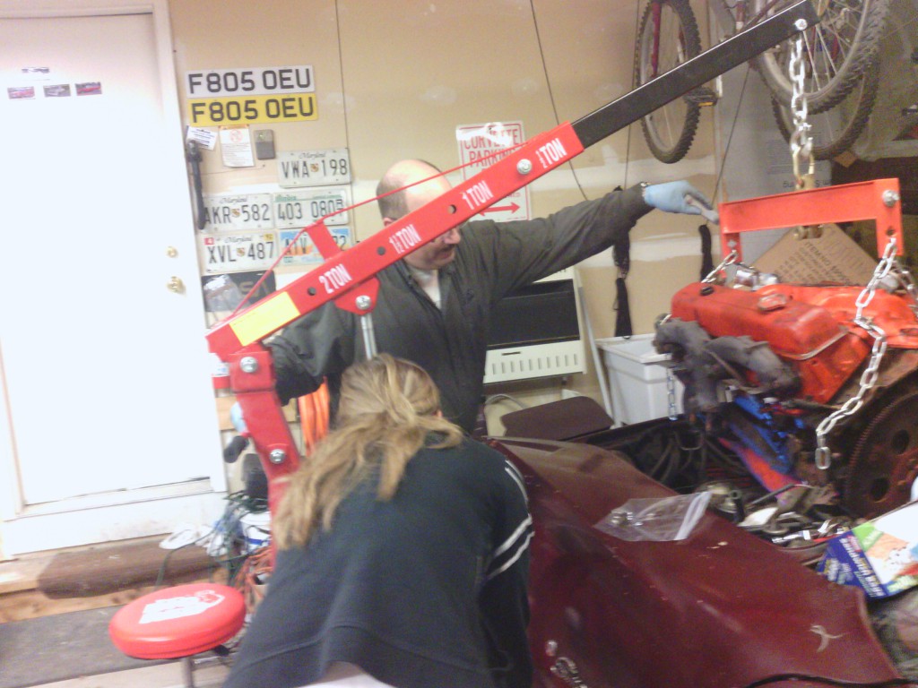 Jackie operating the engine lift while dad guides the engine.