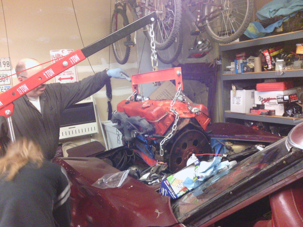 Jackie operating the engine lift while dad guides the rngine.